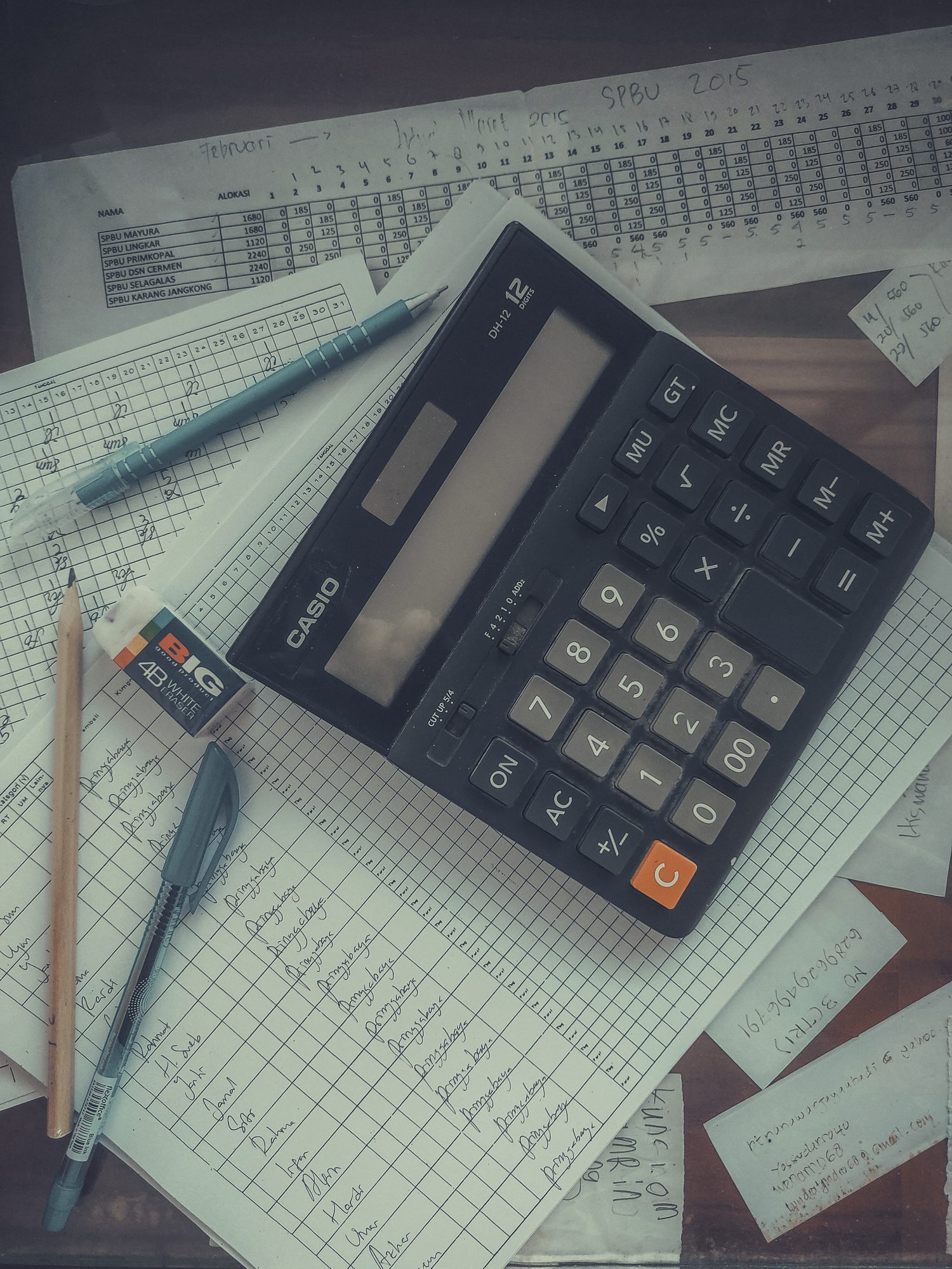 Calculadora e folhas de conta sobre a mesa, sem pessoa na cena