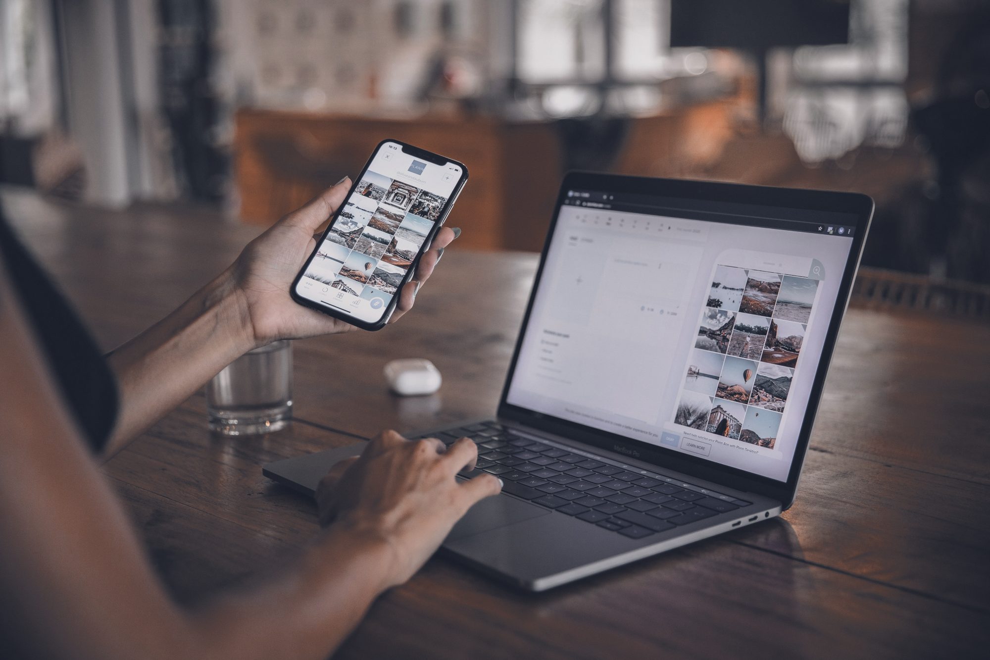 Mãos com o celular ao lado do notebook aberto numa planilha