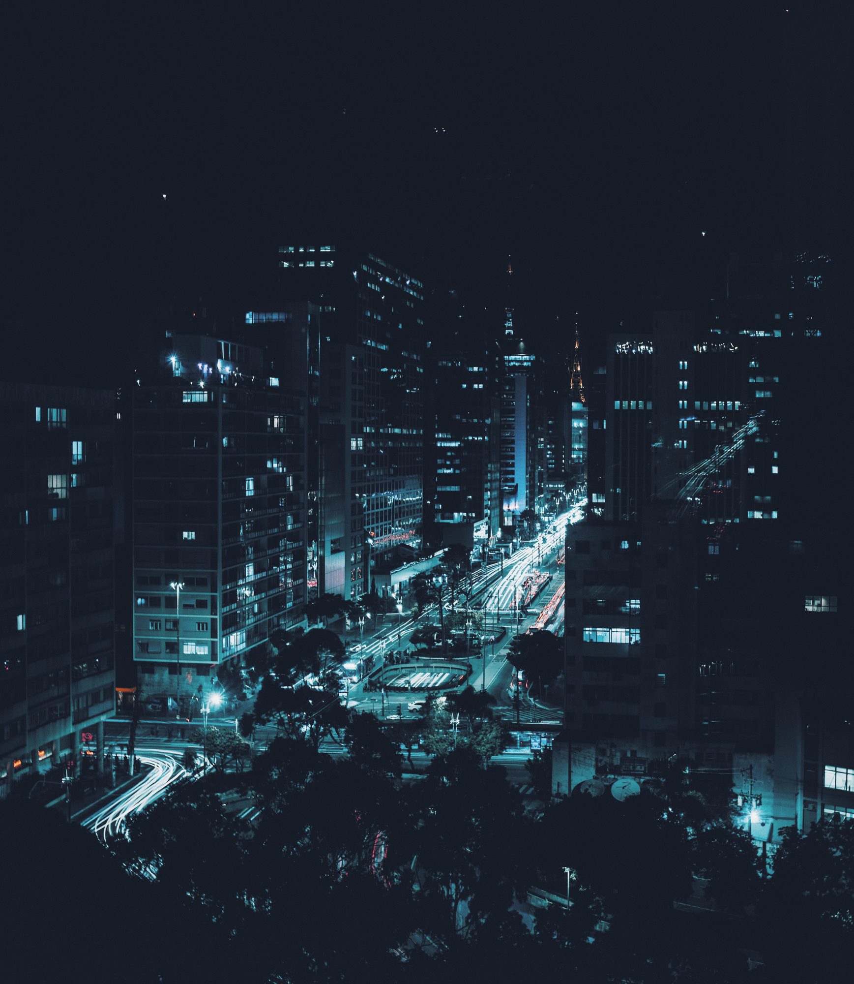 Cidade vista do alto à noite, trânsito iluminado