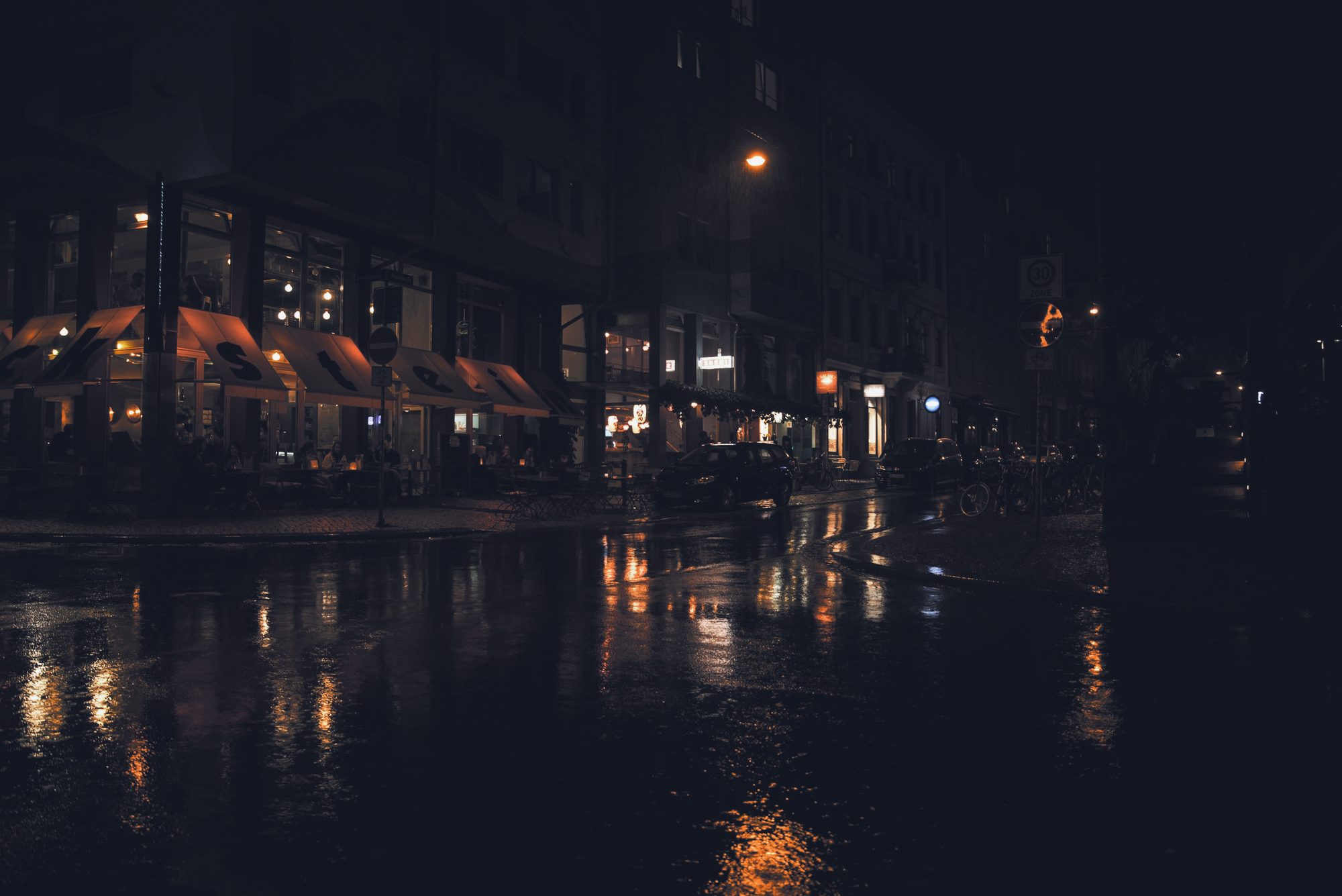 Rua molhada à noite com reflexos quentes
