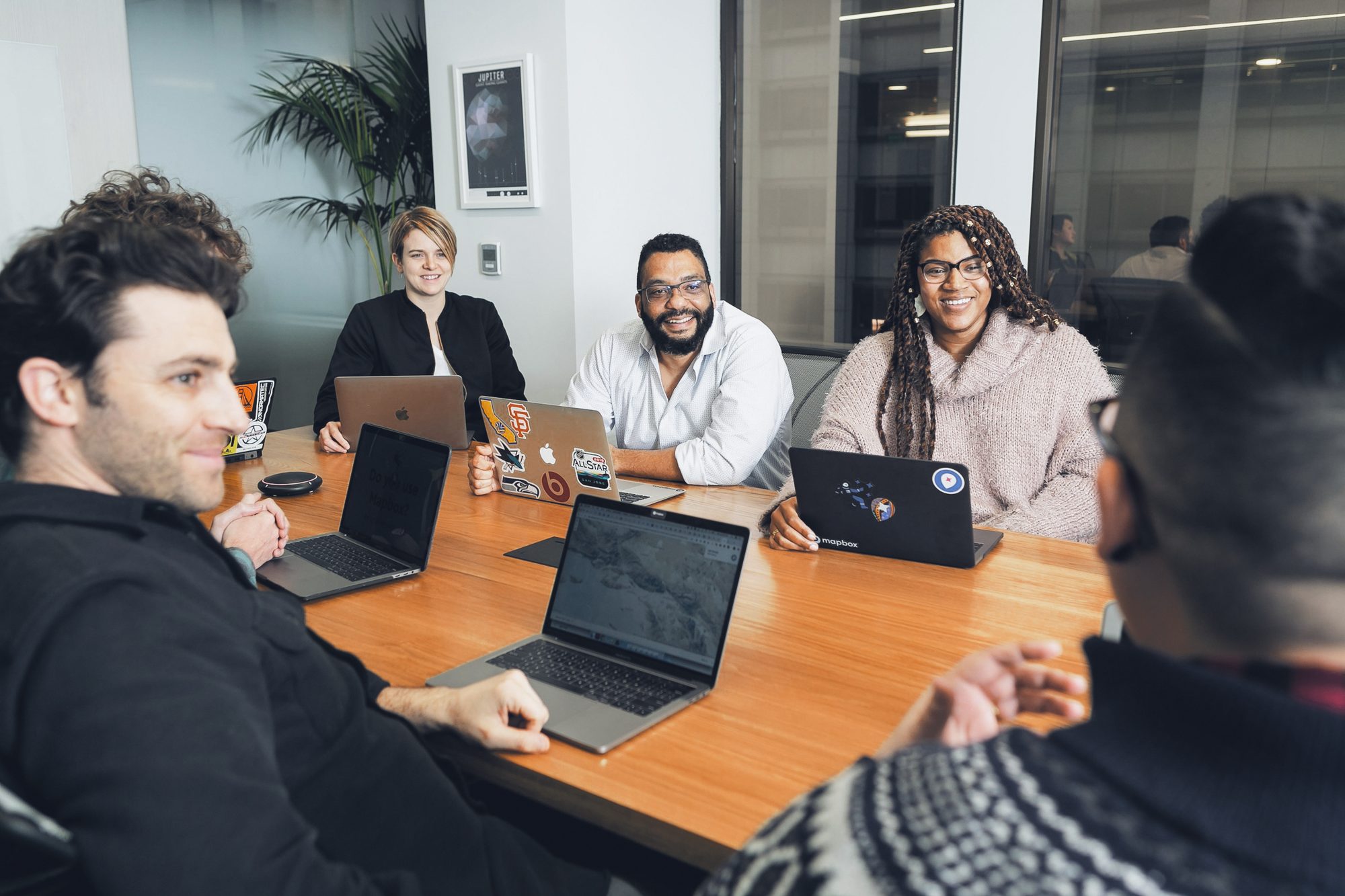 Time pequeno em reunião, notebooks na mesa