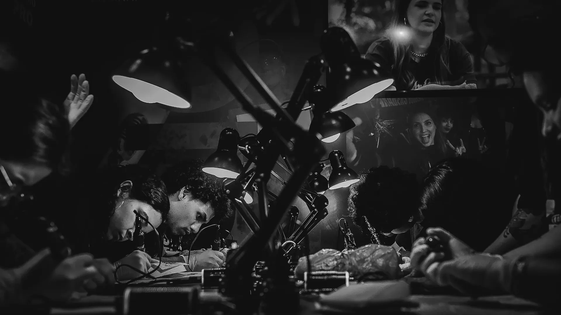Alunos tatuando sob luminárias durante imersão da The VOID, em ambiente escuro