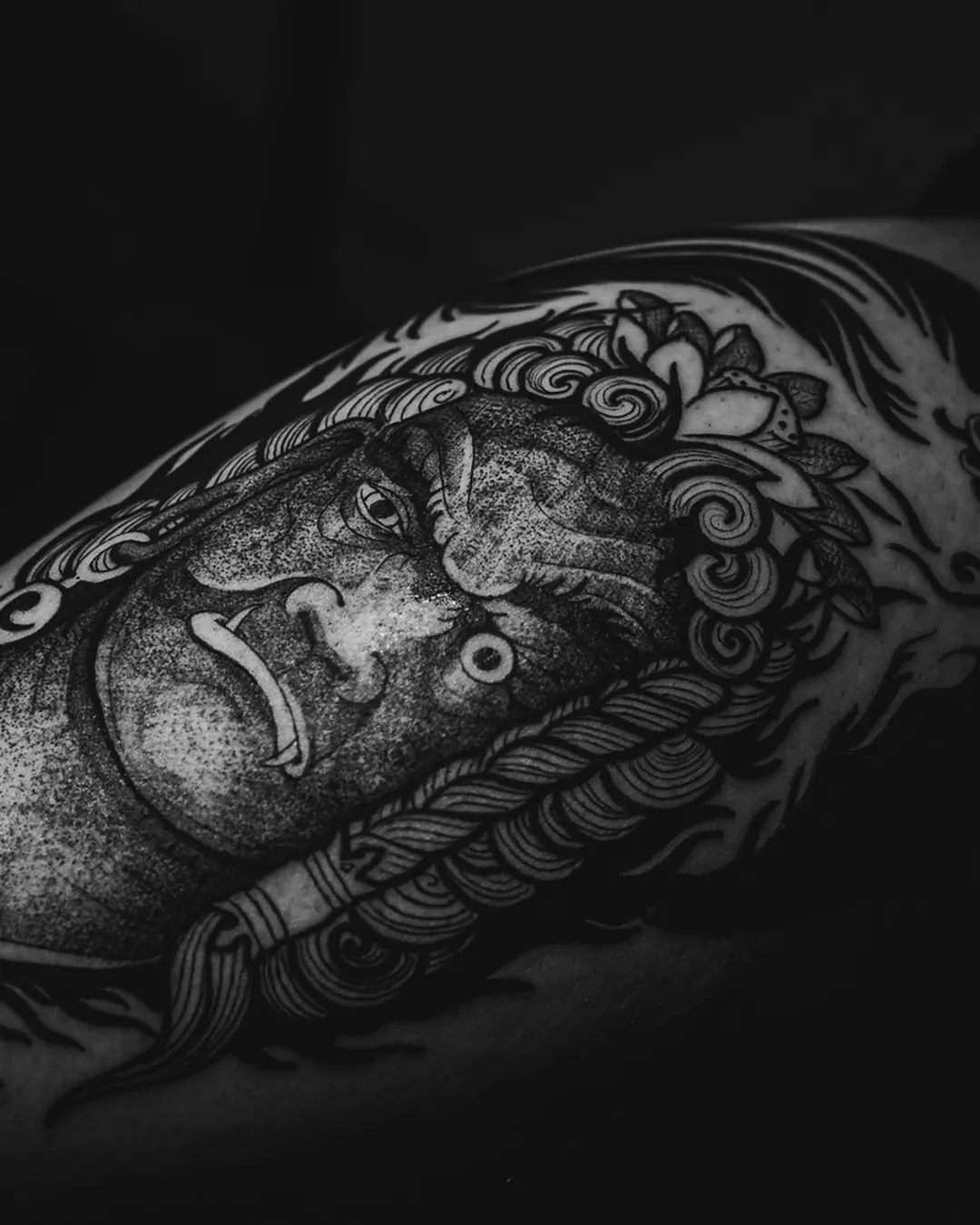 Close de antebraço com tatuagem blackwork sob luz lateral dramática