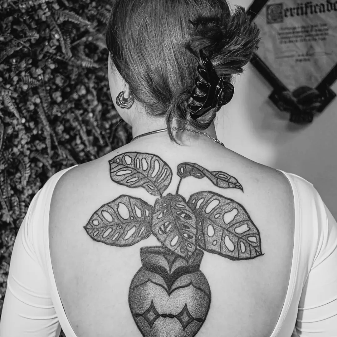 Vaso com costela-de-adão tatuado nas costas, trabalho da aluna Karina na The VOID