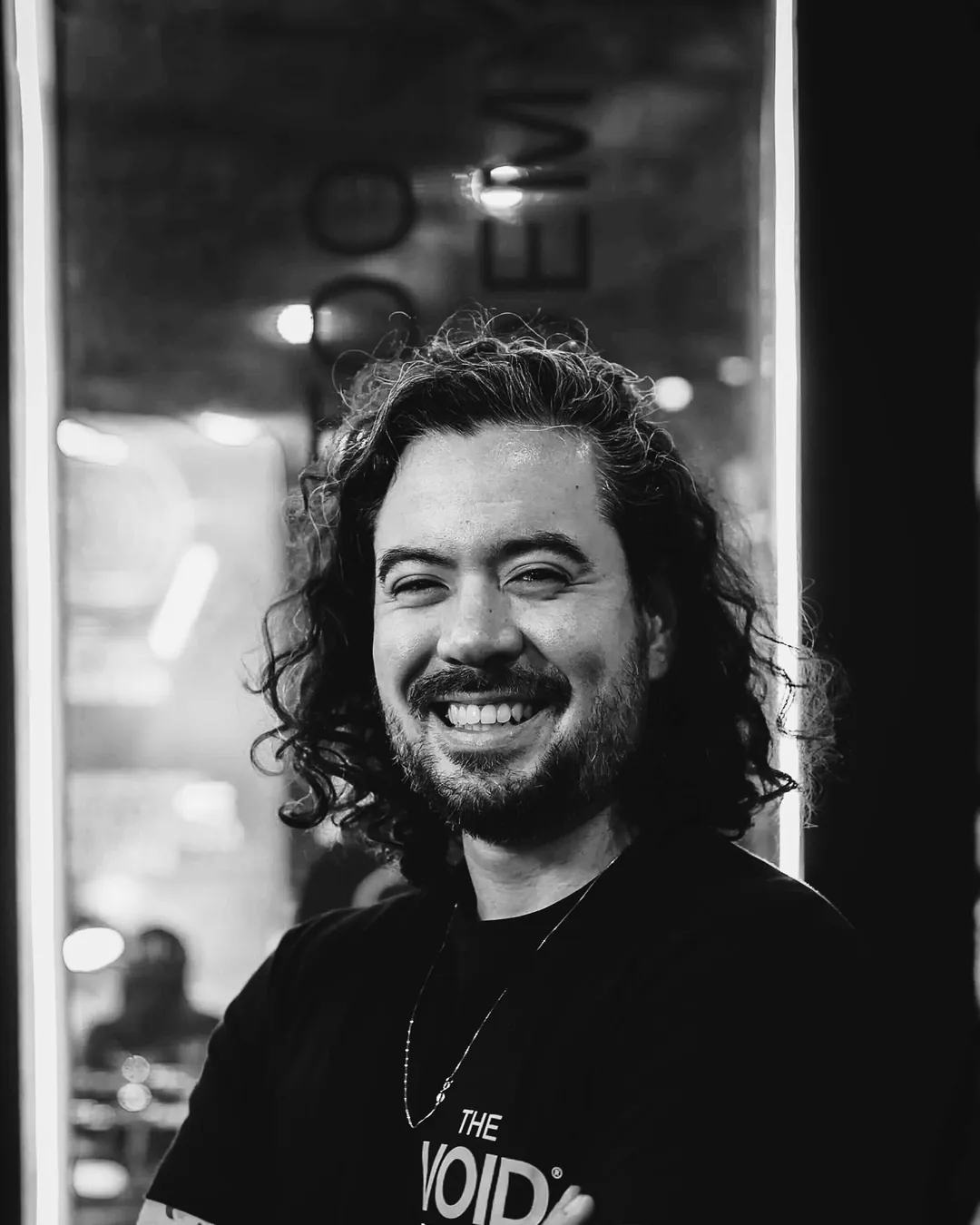 Lucas Tengan, sócio da The VOID, de braços cruzados e camiseta da escola