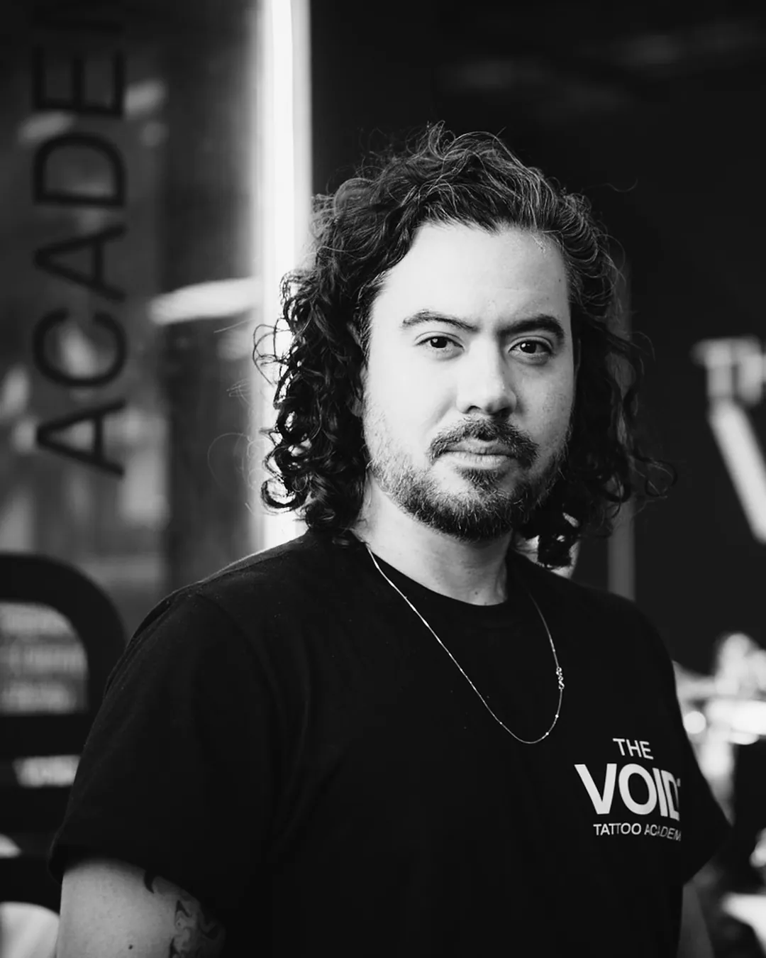 Retrato de Lucas Tengan no estande da The VOID com letreiro iluminado ao fundo
