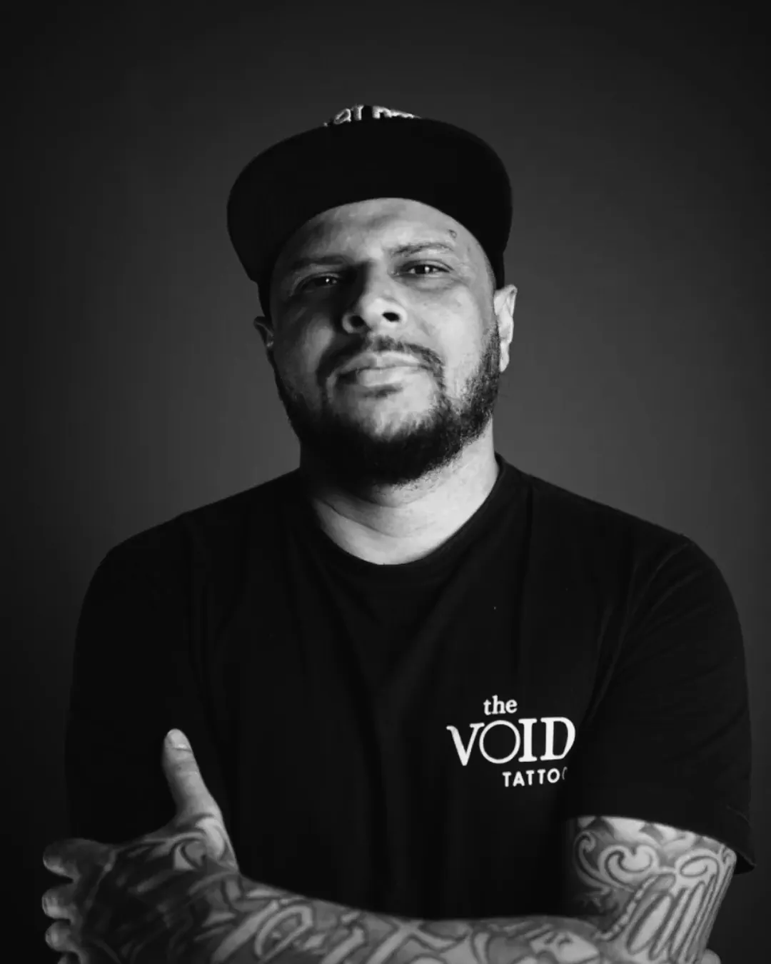 Professor Denis Mota de braços cruzados vestindo camiseta The VOID