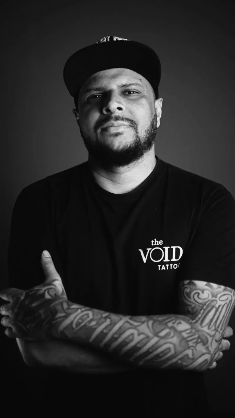 Professor Denis Mota de braços cruzados vestindo camiseta The VOID