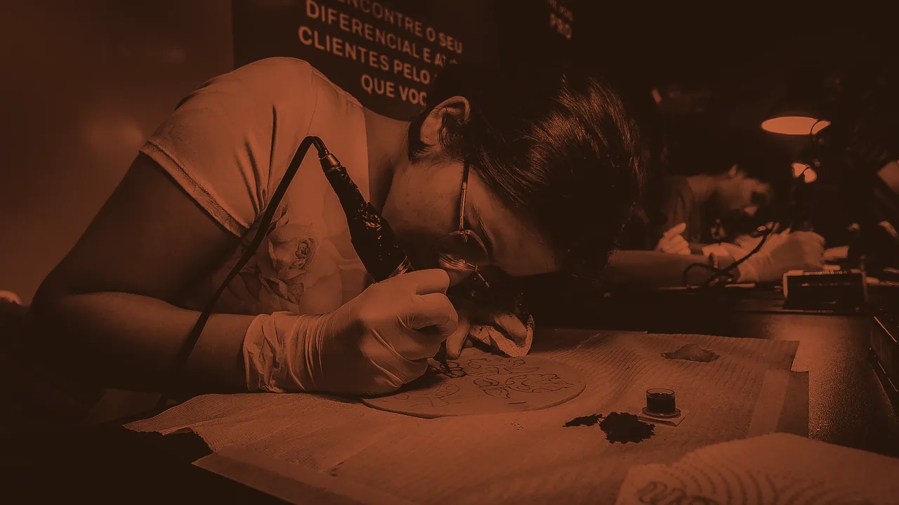 Aluna de óculos e luvas tatuando pele sintética no duotom Master, até Terracota Viva