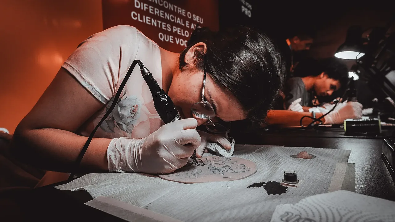 Aluna de óculos e luvas tatuando pele sintética na cor original, sem tratamento