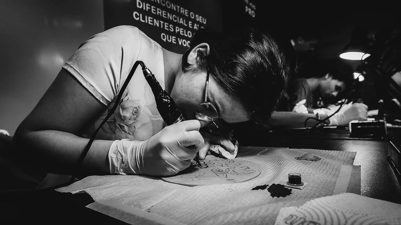 Aluna de óculos e luvas tatuando pele sintética no P&B Ritual