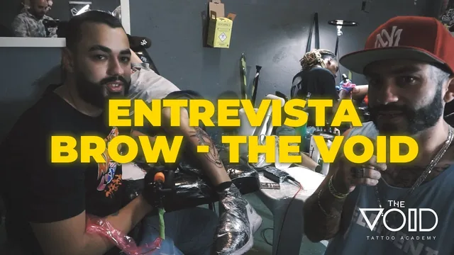 Miniatura atual de entrevista na convenção: dois tatuadores com letreiro amarelo por cima